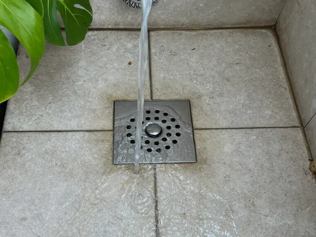 Water flowing into a floor drain in a Bali villa shower